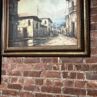 a brick wall with a painting on it