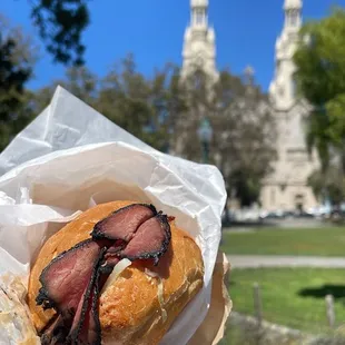 a person holding a sandwich in front of a church