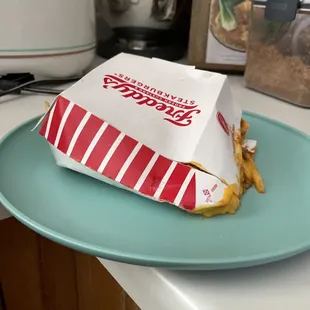 Put at very bottom of bag with two burgers smashing. A person with a brain would of maybe bagged the chili cheese fries separately.