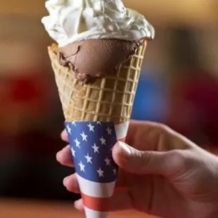 a hand holding a cone of ice cream