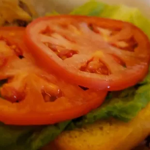 a hamburger with tomatoes and lettuce