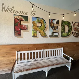 a white bench in front of a welcome sign