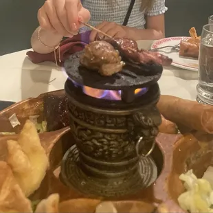 Putting a char on the yummy beef skewer and the paper wrapped chicken.   - Flaming Po Po Platter