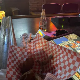 a basket of fried donuts and a bottle of soda
