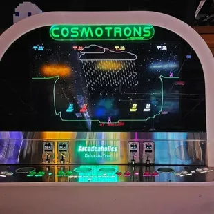 an arcade machine with a neon sign