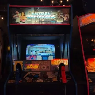 three arcade machines in a dark room