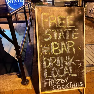 a chalkboard sign on a sidewalk