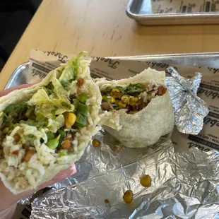 a hand holding a burrito