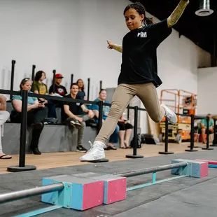 Girl bounds over parkour obstacles