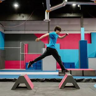 Teen running over the tops of parkour obstacles