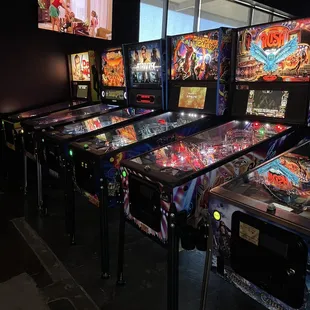 a row of pinball machines in a dark room