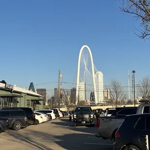 cars parked in a parking lot with the arch in the background
