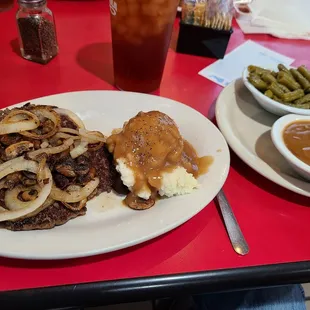Hamburger Steak with salad, mashed potatoes,  green beans and a roll.