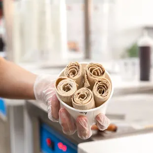 a person holding a cup of ice cream
