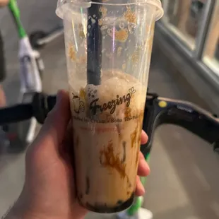 a hand holding a cup of iced coffee