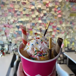 a hand holding a cup of ice cream