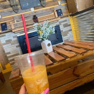 a person holding a glass of orange juice