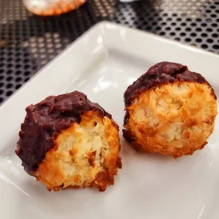 two chocolate covered donuts on a white plate