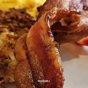 Breakfast, scrambles, bacon, potato pancake, biscuit.