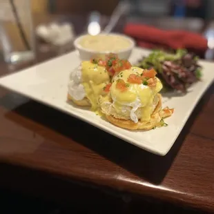 Crab Cake Benedict with cheddar grits and and a vinaigrette dressed mixed green salad
