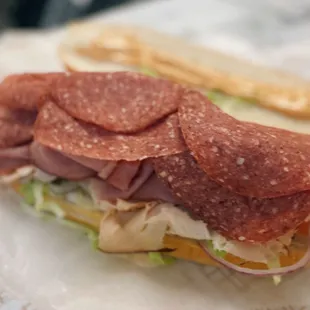 a sandwich with pepperoni and lettuce