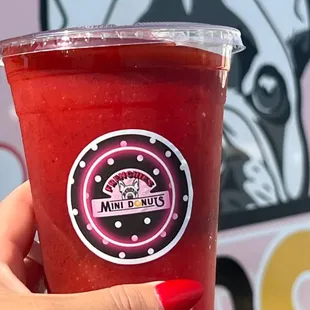 a hand holding a red drink