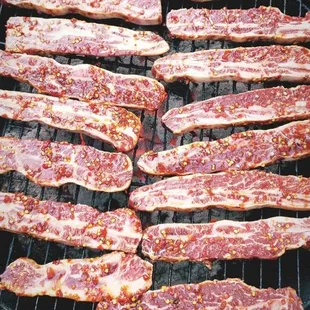 bacon cooking on a charcoal grill