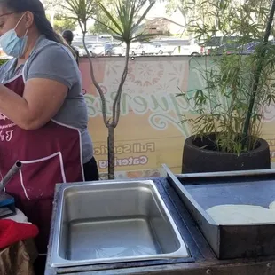 a woman wearing a face mask preparing food