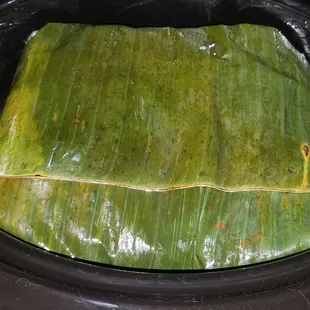 Cochinita Pibil - all wrapped in  banana leaves and sitting in crock pot on a bed of onions  to cook (all items purchased at Fresco y Mas)