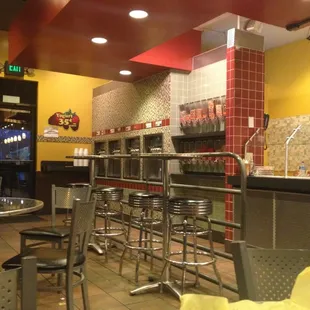 Part of the dining room. Frozen yogurt machines and toppings along the wall.