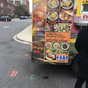 a woman standing in front of a food truck