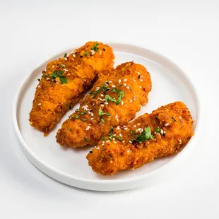three pieces of fried chicken on a white plate