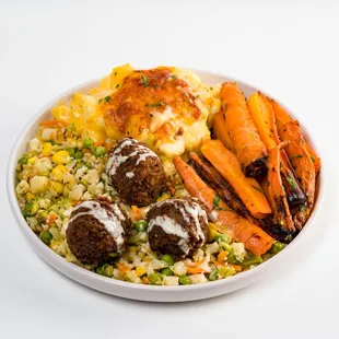 a bowl of food with carrots and meatballs