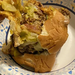 a hand holding a half eaten hamburger