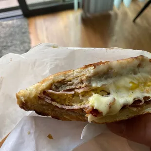 a hand holding a sandwich