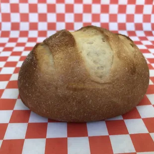 a loaf of bread on a checkered tablecloth