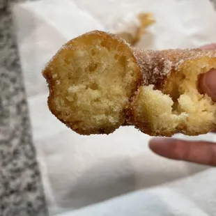 a hand holding a half eaten donut