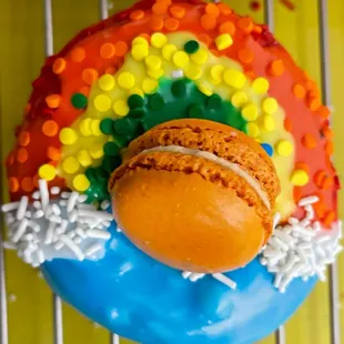 a rainbow colored donut on a cooling rack