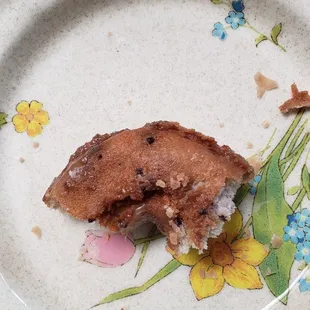 Dry, hard, unglazed bottom of a blueberry donut