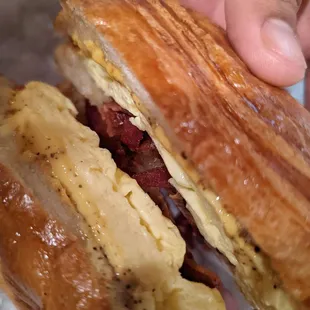 a hand holding a sandwich