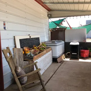 a wooden rocking chair and fruit stand