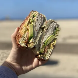 a hand holding a sandwich