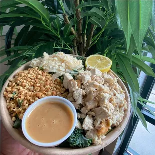 a bowl of food with a side of sauce