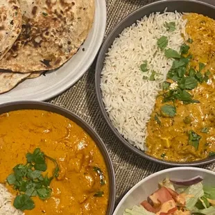 Butter chicken, side salads and garlic naan