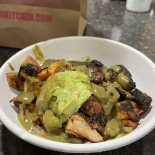 Bowl with herb blackened chicken, avocado, sweet potatoes, and herb vinaigrette.