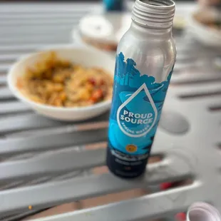 a bottle of water and a bowl of food