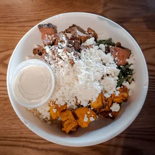 a bowl of rice, meat, and vegetables