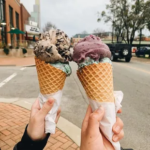 two people holding ice cream cones