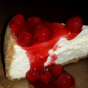 a slice of cheesecake with cherries