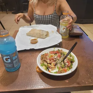 a woman sitting at a table with a plate of food